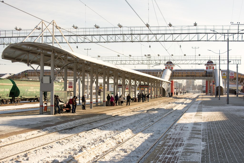 Вид на железнодорожные пути, люди в ожидании поезда